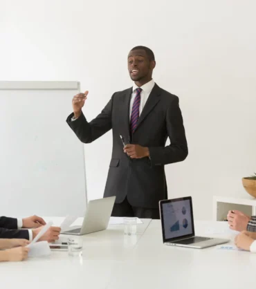 Confident african speaker or business coach giving presentation How to Lead Remote Teams Effectively in a Hybrid Work World